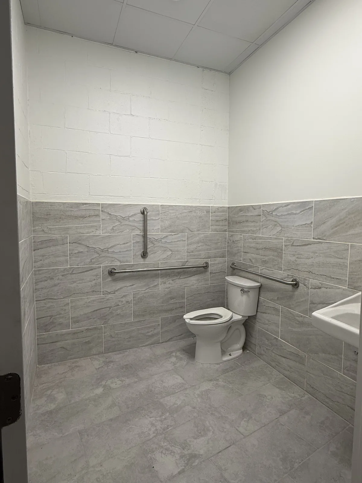 Second shared restroom, fully tiled with grab bars